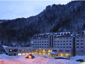 雪景色の峡谷をバックにライトアップされた朝陽リゾートホテル(12月~3月頃)
