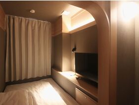 【ドミトリー／女性専用】枕元にコンセント、読書灯、クッションを備え付けています。