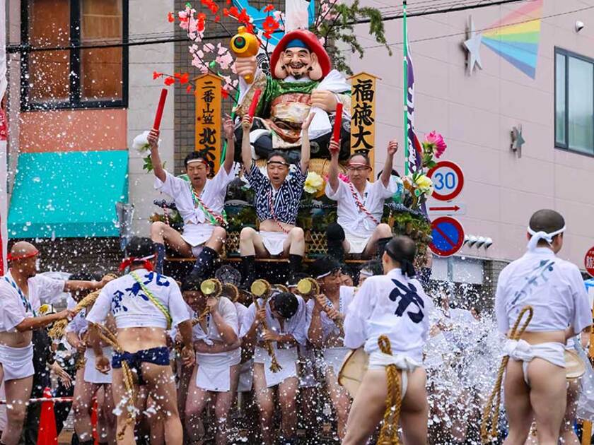 締め込み法被姿の男たちが先導からの水を浴び、約1トンの山笠を舁き疾走する姿は迫力満点