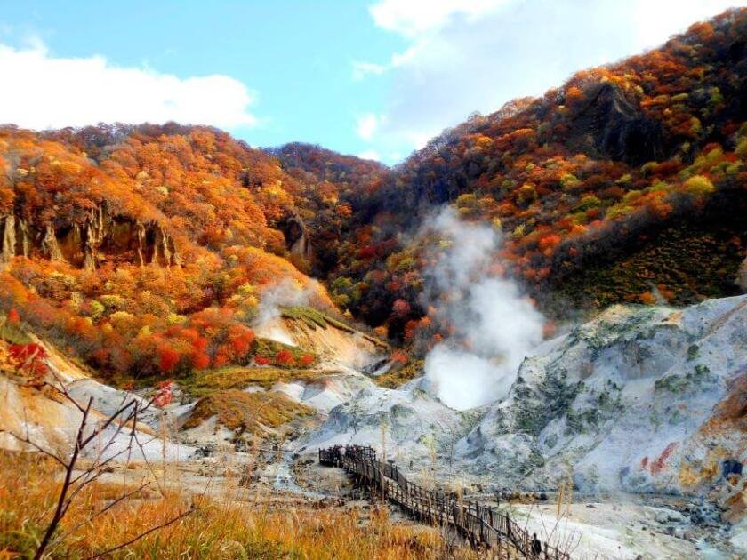 地の底から熱湯や水蒸気が、もうもうと立ち上がる登別地獄谷の紅葉風景