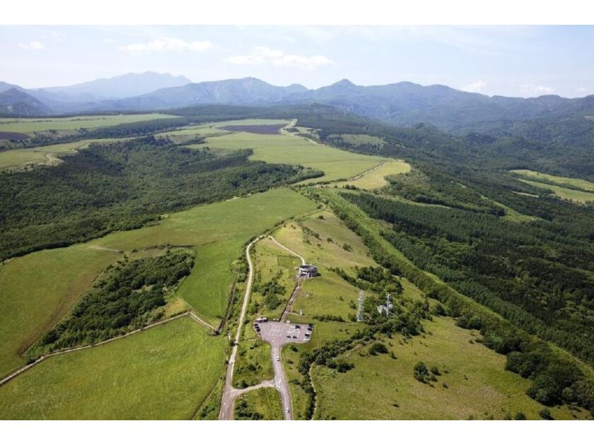 標高270mに立つ展望館からは、どこまでも続く根釧原野の緑を一望できます。丸みを帯びた地平線に溶け込む景観は感動的