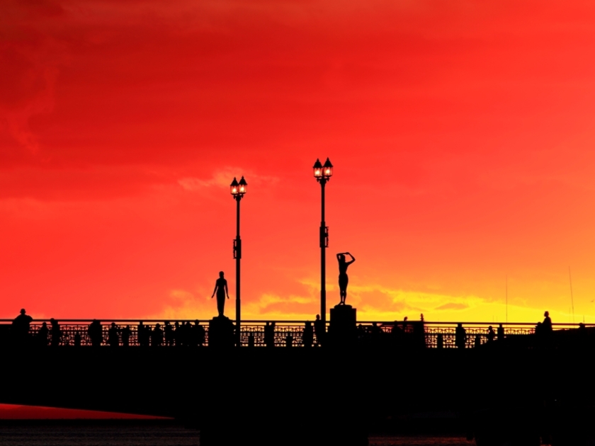 橋の欄干にたたずむ四季の像のシルエット越しに望む夕日は、まさに絶景で、夕日の観光スポットして大人気です