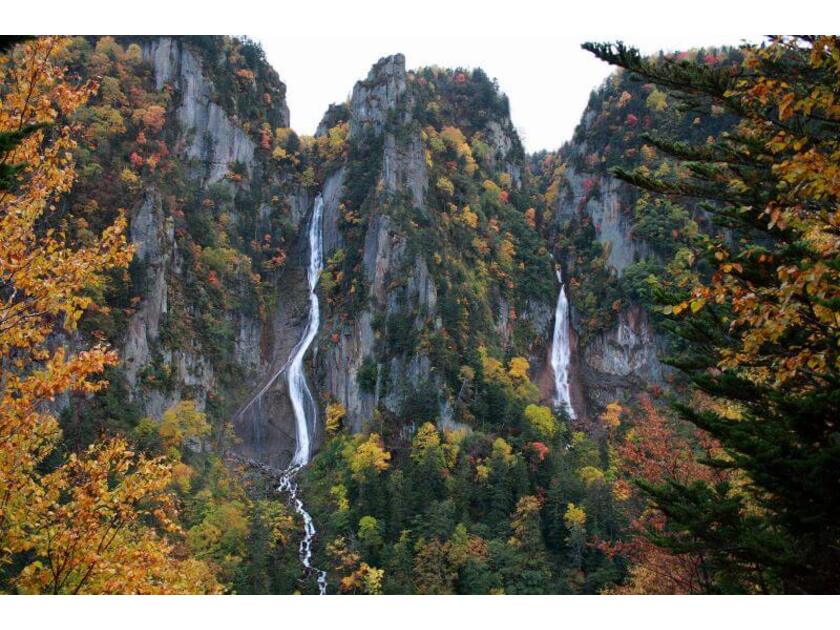 紅葉に彩られてひときわ美しい流星・銀河の滝。左が繊細な白糸のように流れ落ちる「銀河の滝」。右が太く力強く流れ落ちる「流星の滝」