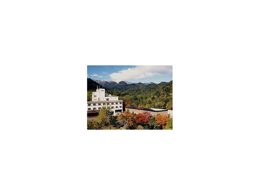 秋色に染まる山々に囲まれた糠平館観光ホテルの全景。近くには「ひがし大雪博物館」や「ぬかびら源泉郷スキー場」などのスポットも