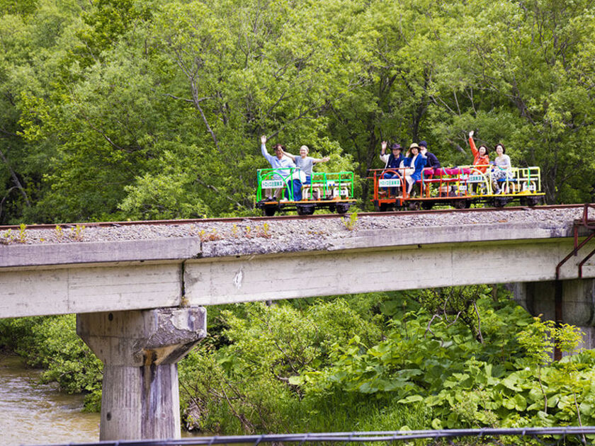 途中には両サイドに防護柵がないドキドキの鉄橋や、車優先でトロッコが一時停止する踏切があります。安全運転でゴー！