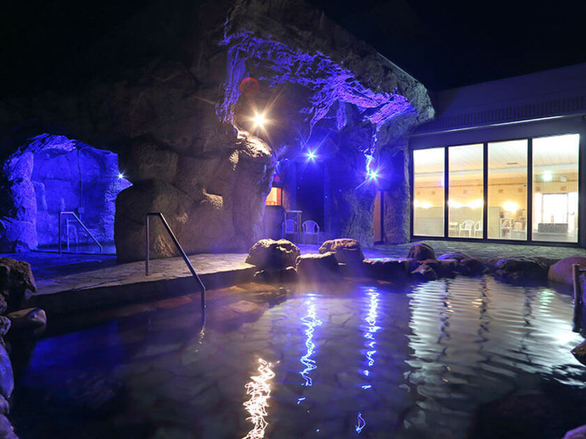 青くライトアップされた夜の洞窟露天風呂は幻想的な空間